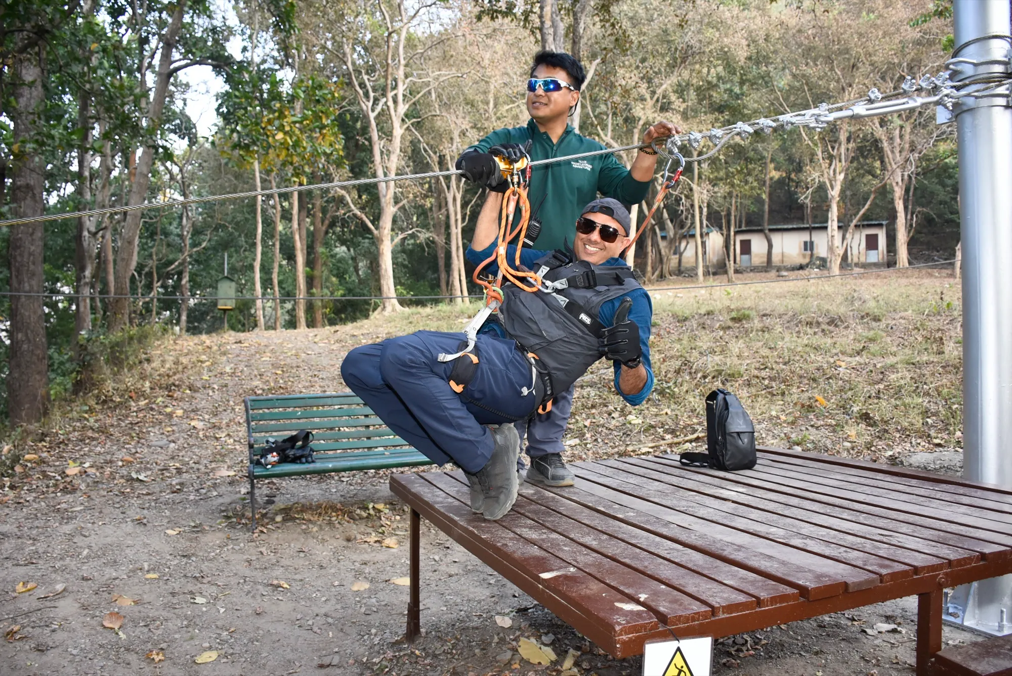 Instructor helping a guest into a harness before the flight