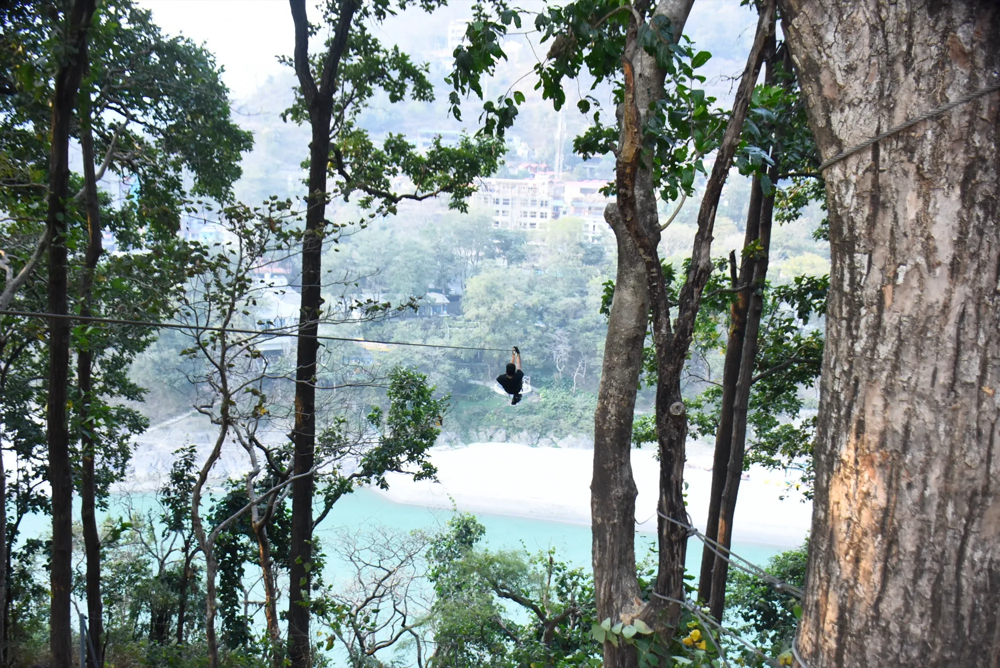 Instructor performing a safety check on zipline equipment